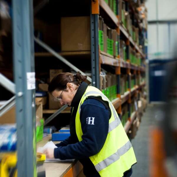 A member of the Ark-H team busy packing an order